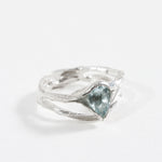 Side-angled view of the sterling silver ring with a faceted aquamarine gemstone.
