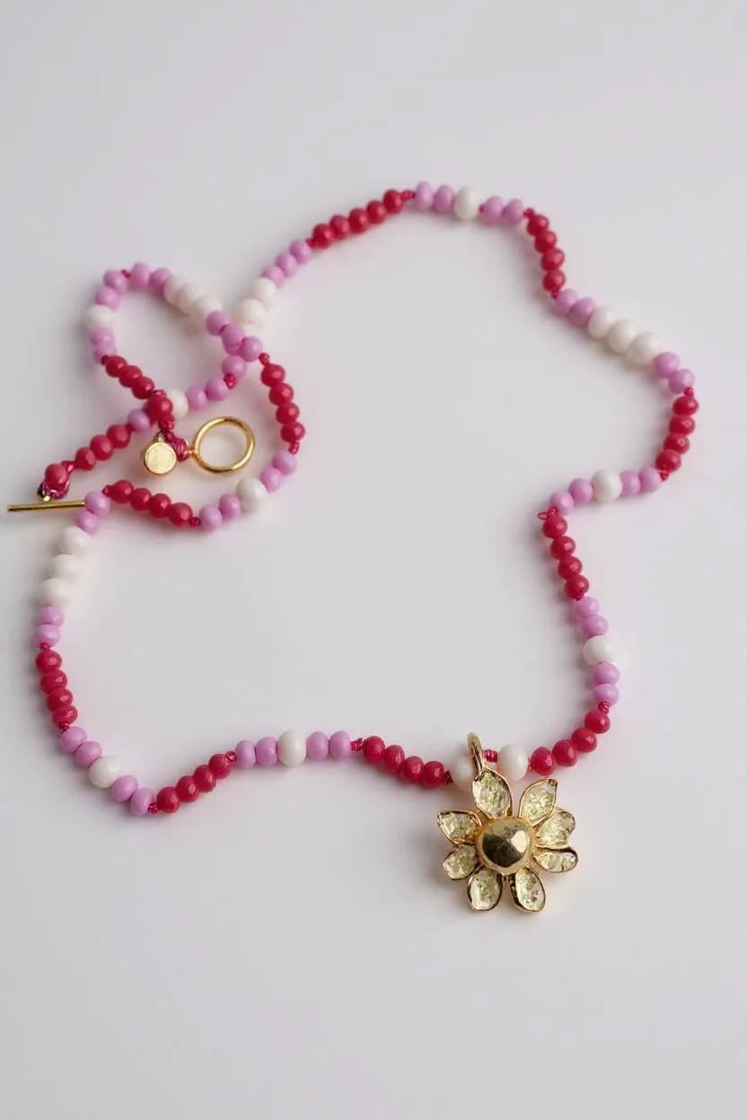 Handmade Daisy Necklace with golden flower pendant, arranged in a circle on white background.