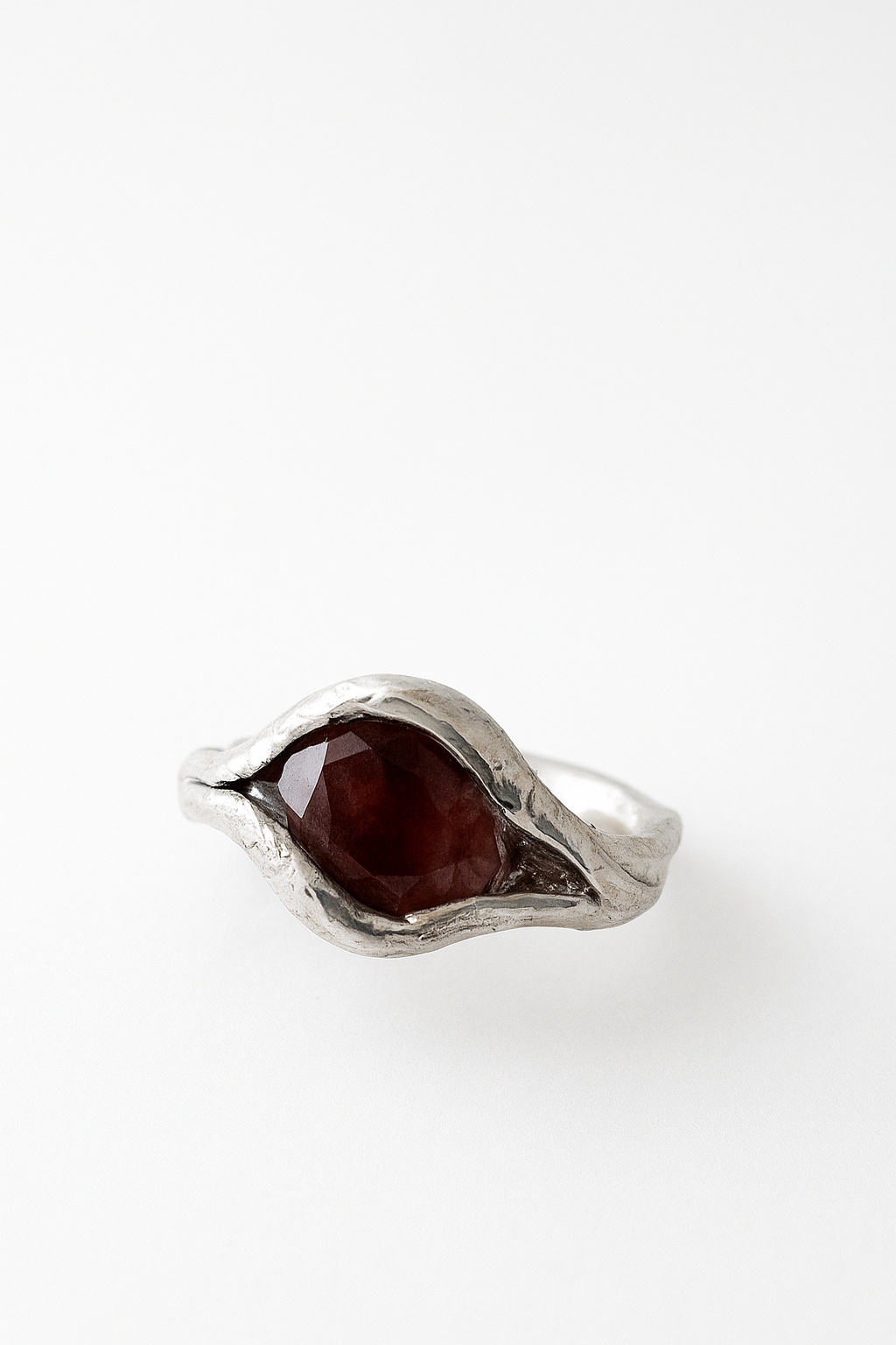 Close-up of the sterling silver ring featuring an oval sunstone set organically in the band, captured from above.