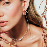 Red elderberry earrings in gold-plated brass with botanical texture, worn by a model with a light background and plant composition.