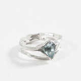 Side-angled view of the sterling silver ring with a faceted aquamarine gemstone.