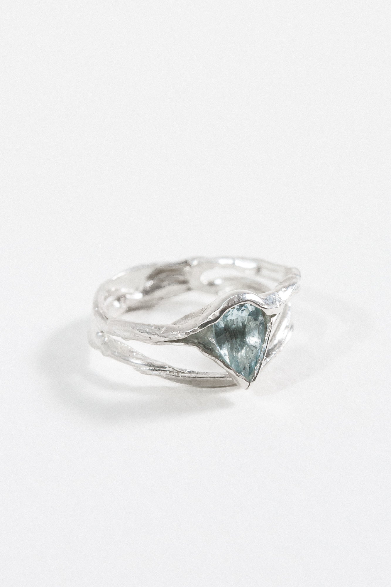 Side-angled view of the sterling silver ring with a faceted aquamarine gemstone.