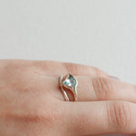 Aquamarine silver ring worn on the hand, showing its natural shine and organic setting.