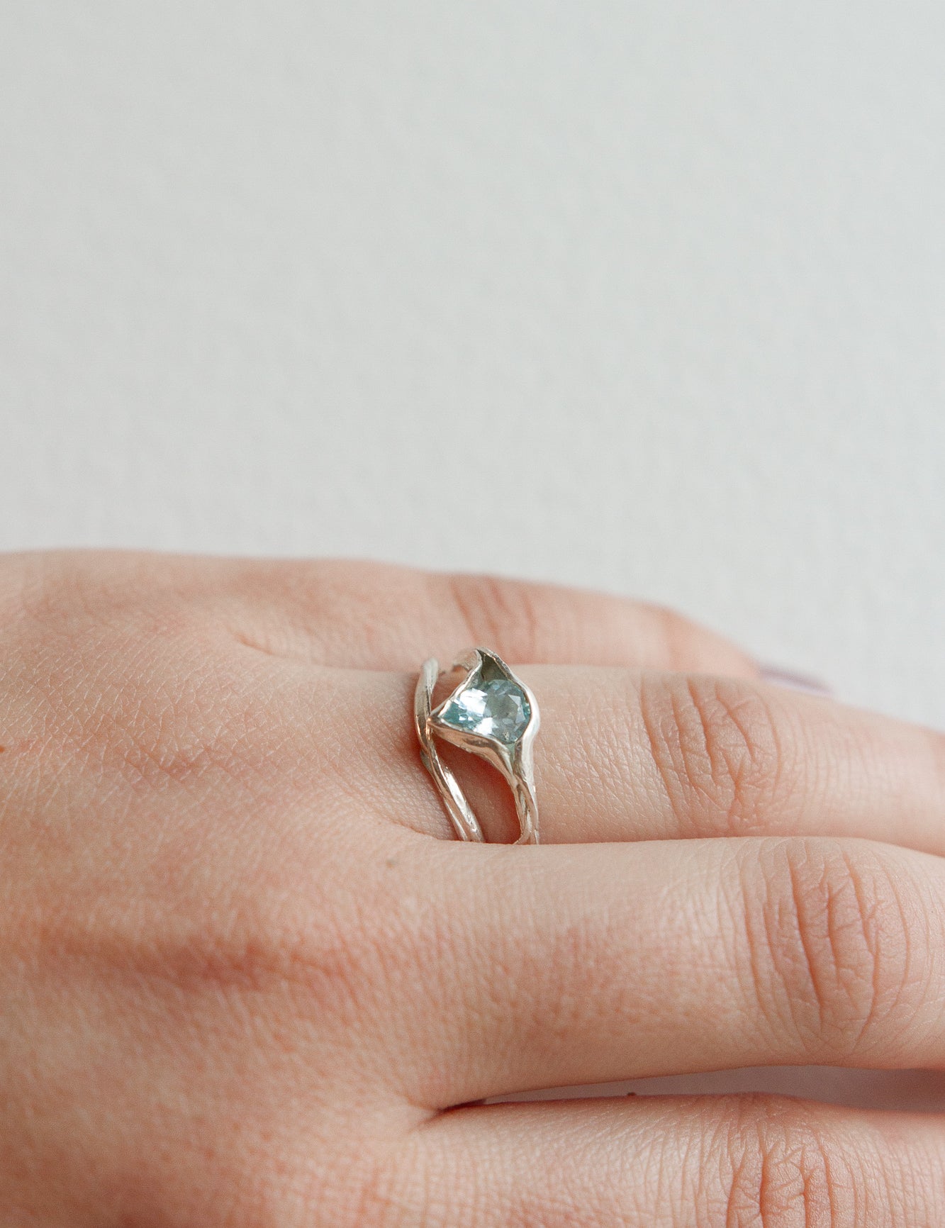 Aquamarine silver ring worn on the hand, showing its natural shine and organic setting.