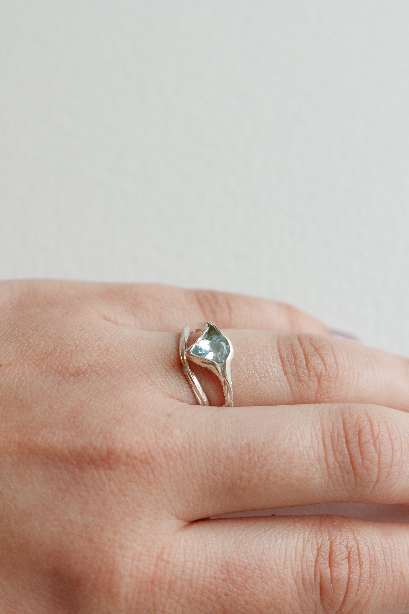 Aquamarine silver ring worn on the hand, showing its natural shine and organic setting.