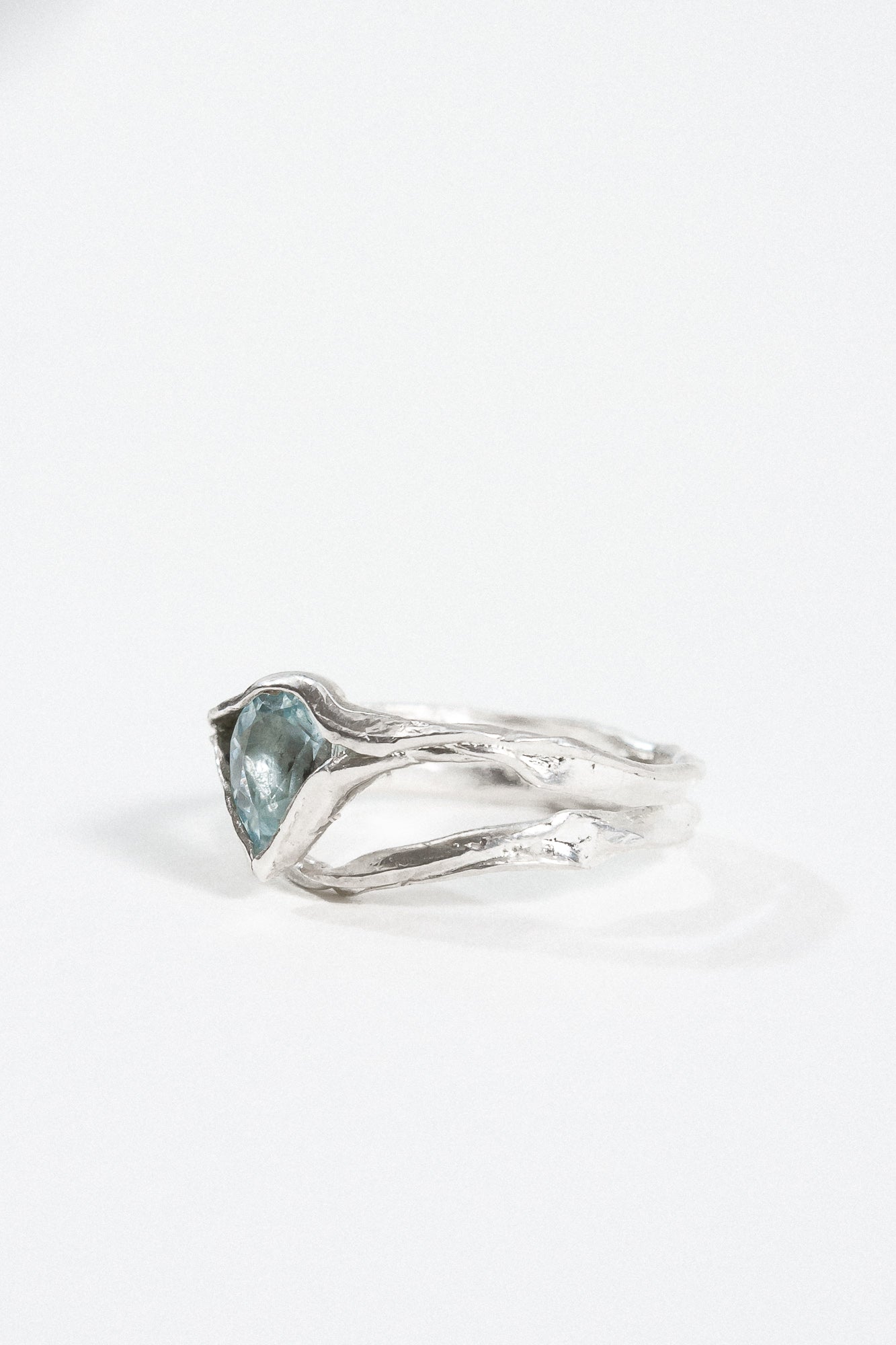 “Profile view of the aquamarine ring highlighting the textured silver band.