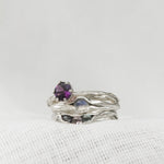 Sterling silver amethyst ring stacked with two additional textured silver bands, displayed on a white background.