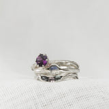 Sterling silver amethyst ring stacked with two additional textured silver bands, displayed on a white background.