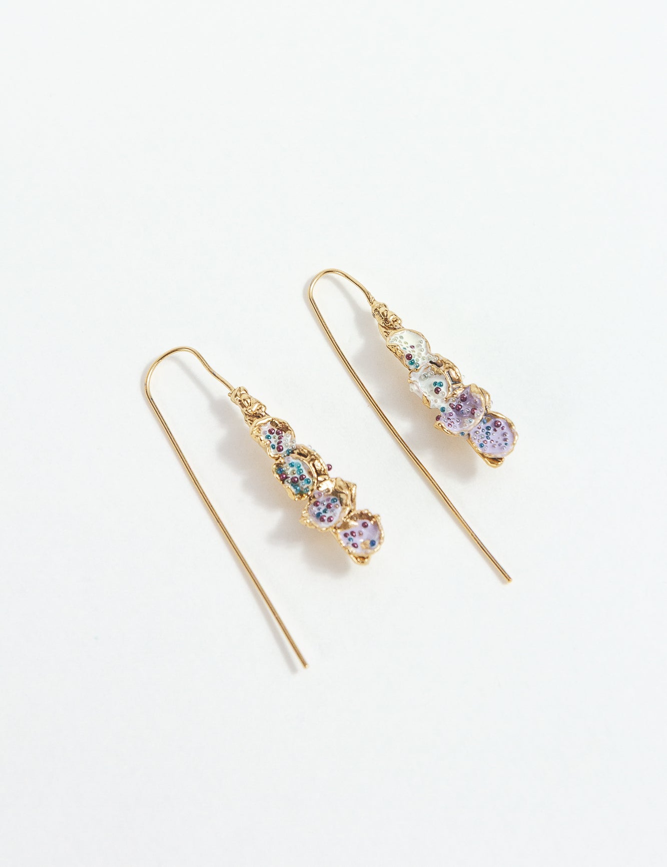 Gold-plated brass Azahar Earrings with lavender details, organic design, and elongated shape on a white background.