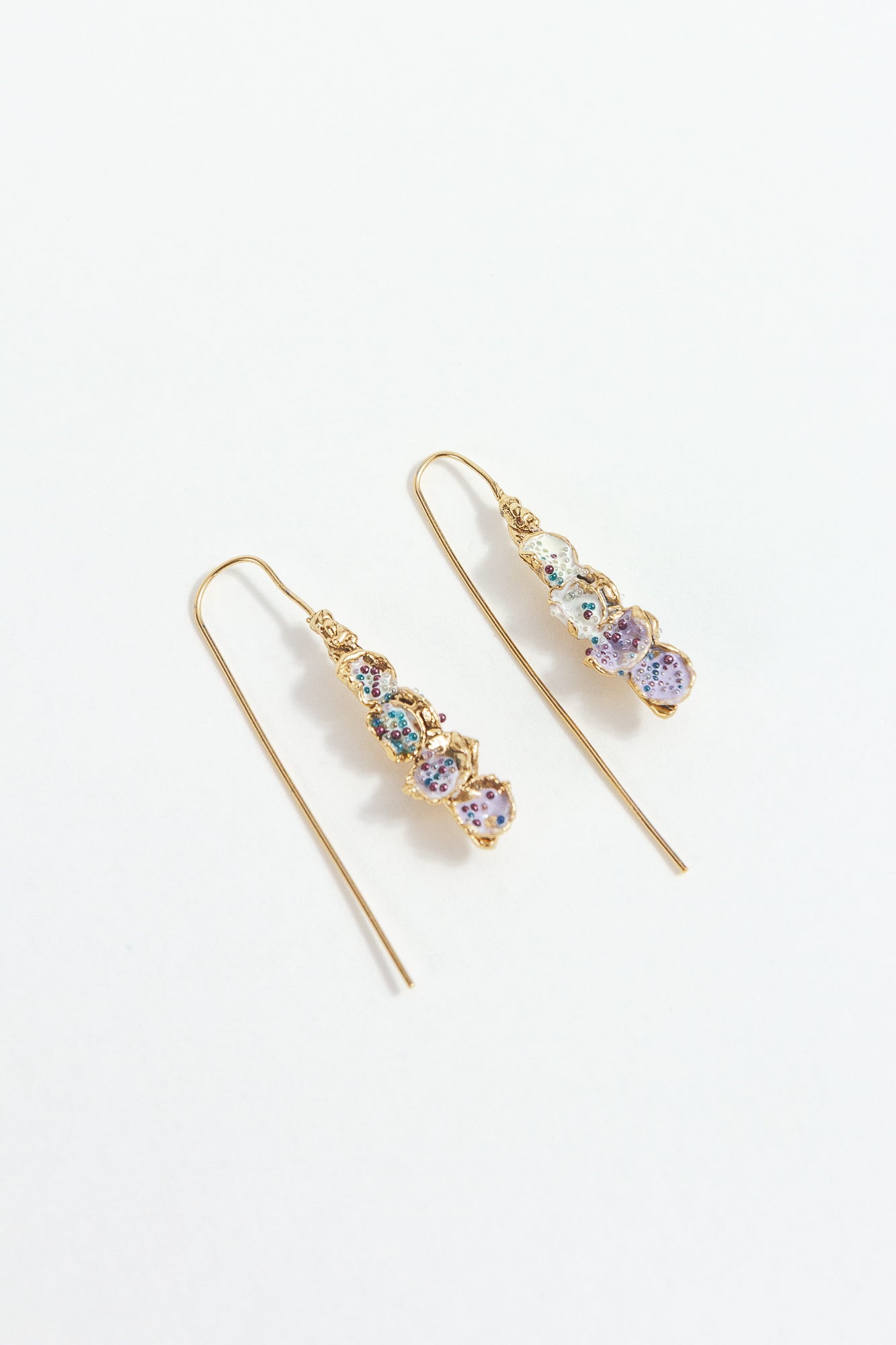 Gold-plated brass Azahar Earrings with lavender details, organic design, and elongated shape on a white background.