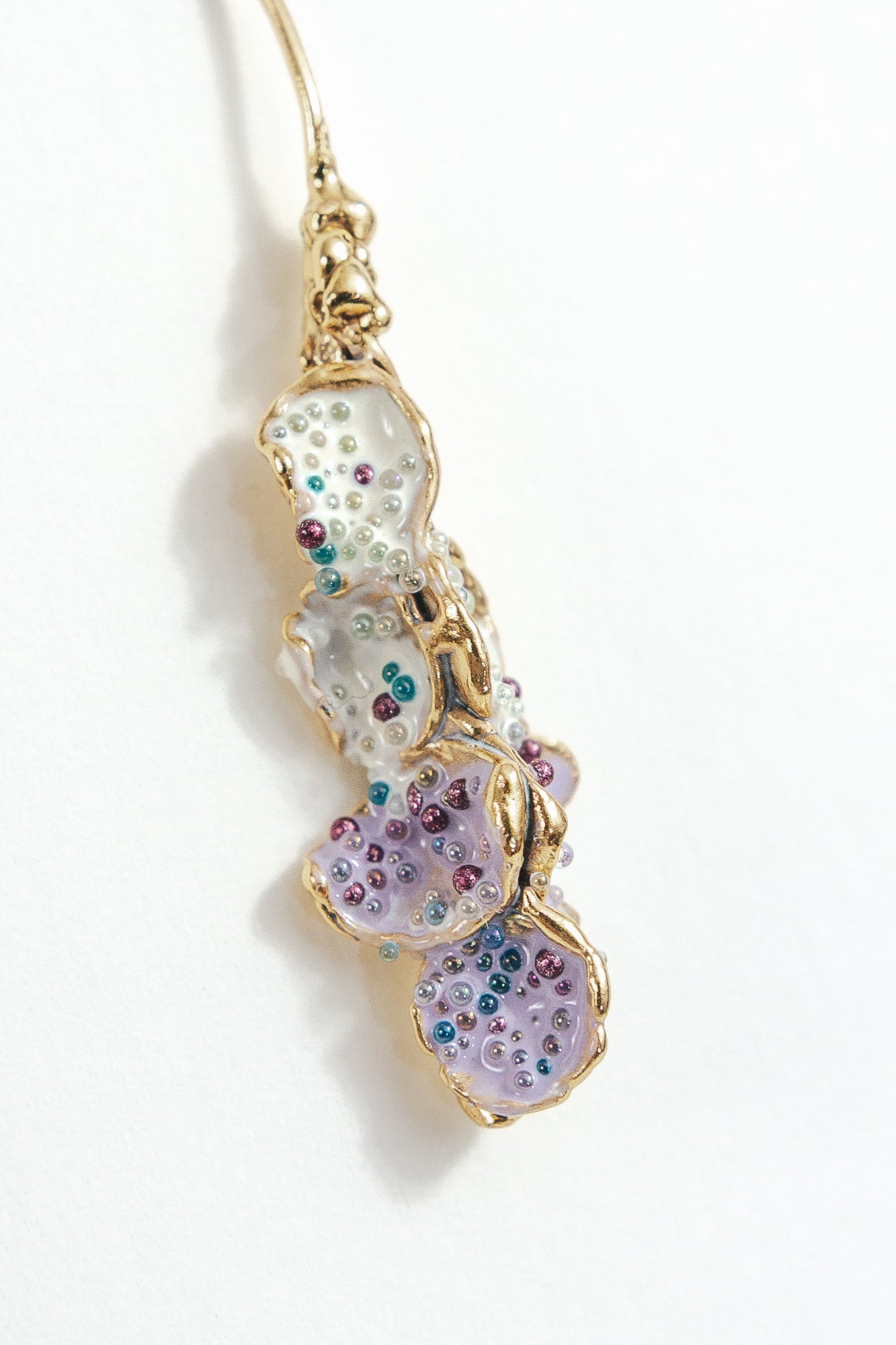 Close-up detail of the textured, hand-painted design of the Azahar Earrings in lavender tones.