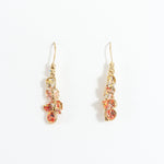 Azahar Earrings in gold-plated brass with red details, botanical design, and handcrafted finish, on a white background.