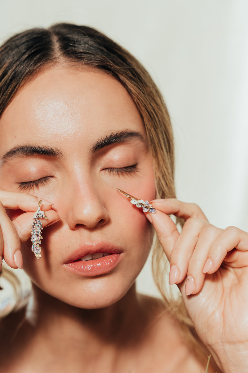 Close-up of model showing Azahar Earrings in a soft, natural setting.