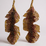 Pair of Banana Leaf Earrings in gold-plated brass hand-painted rust with glass granulation detail, displayed against a white background.