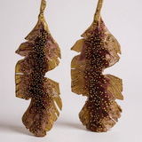 Pair of Banana Leaf Earrings in gold-plated brass hand-painted rust with glass granulation detail, displayed against a white background.