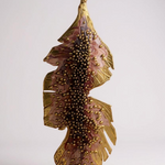 Single Banana Leaf Earring placed vertically on a white background, showing the rust-painted variant with glass granulation in a gold-plated bronze setting
