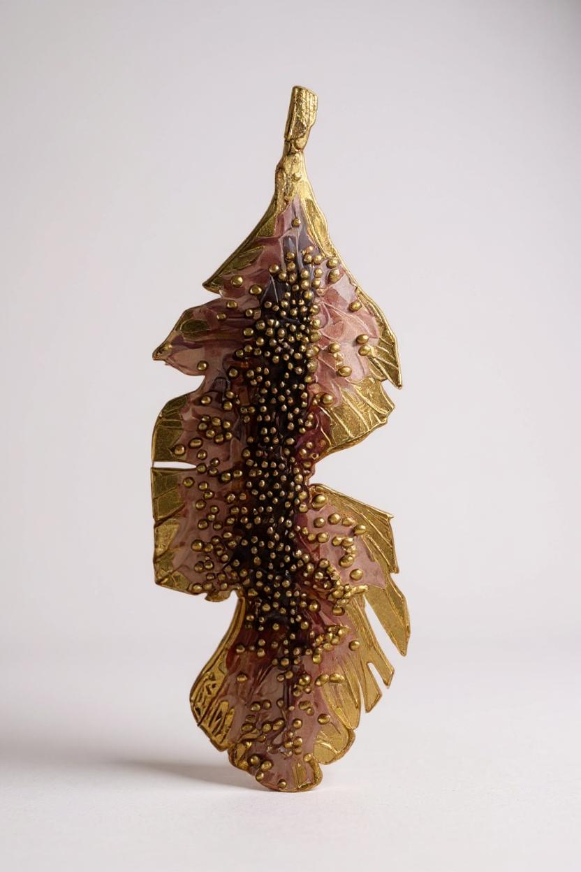 Single Banana Leaf Earring placed vertically on a white background, showing the rust-painted variant with glass granulation in a gold-plated bronze setting