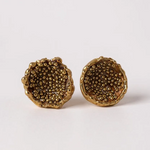 “Flat lay of a pair of Topos Coca M stud earrings in gold-plated bronze, hand-painted in rust with glass granulation, on a white background.
