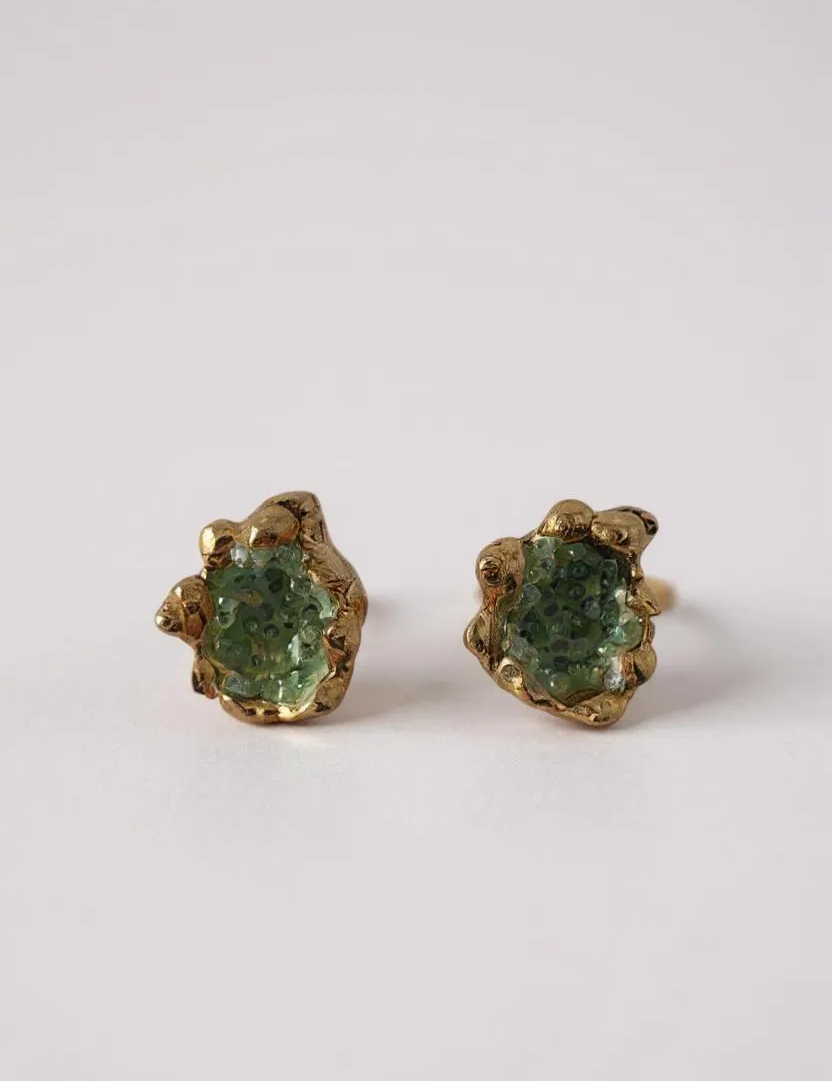 Pair of Topos Coca S stud earrings with green glass granulation and paint in scalloped gold-tone bezels, displayed on a white background.