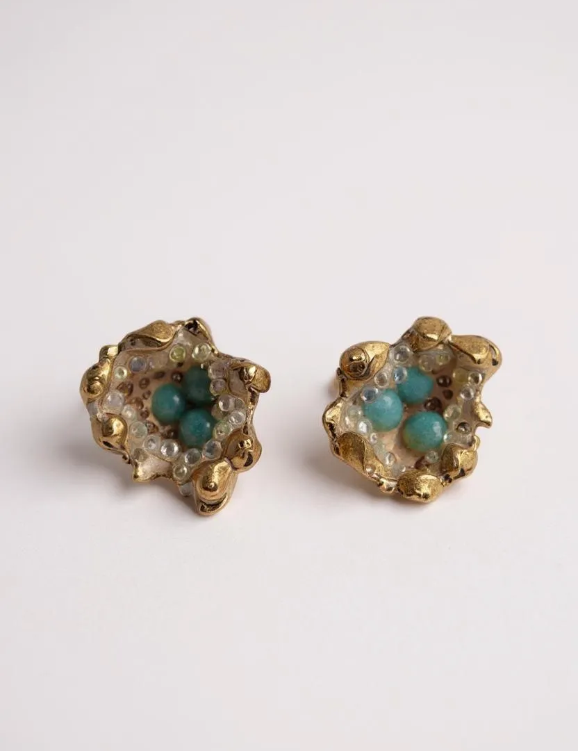 Pair of Topos Coca S stud earrings with sunset paint and turquoise glass granulation in gold-tone settings, displayed on a white background.