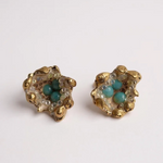 Pair of Topos Coca S stud earrings with sunset paint and turquoise glass granulation in gold-tone settings, displayed on a white background.