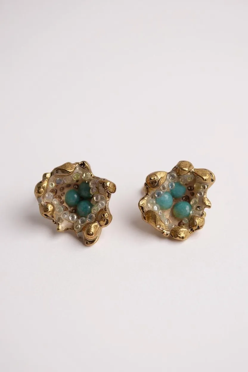 Pair of Topos Coca S stud earrings with sunset paint and turquoise glass granulation in gold-tone settings, displayed on a white background.