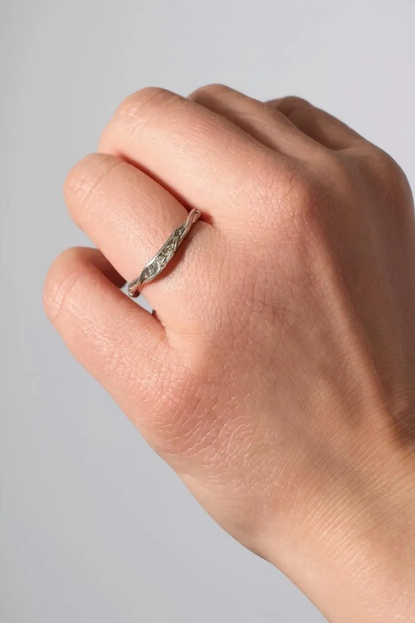 Silver ring with lab-grown diamonds worn on a finger, showing how it looks when worn.