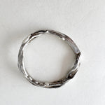 Silver ring viewed from above, showcasing its circular shape and organic texture with small lab-grown diamonds.