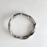 Silver ring viewed from above, showcasing its circular shape and organic texture with small lab-grown diamonds.