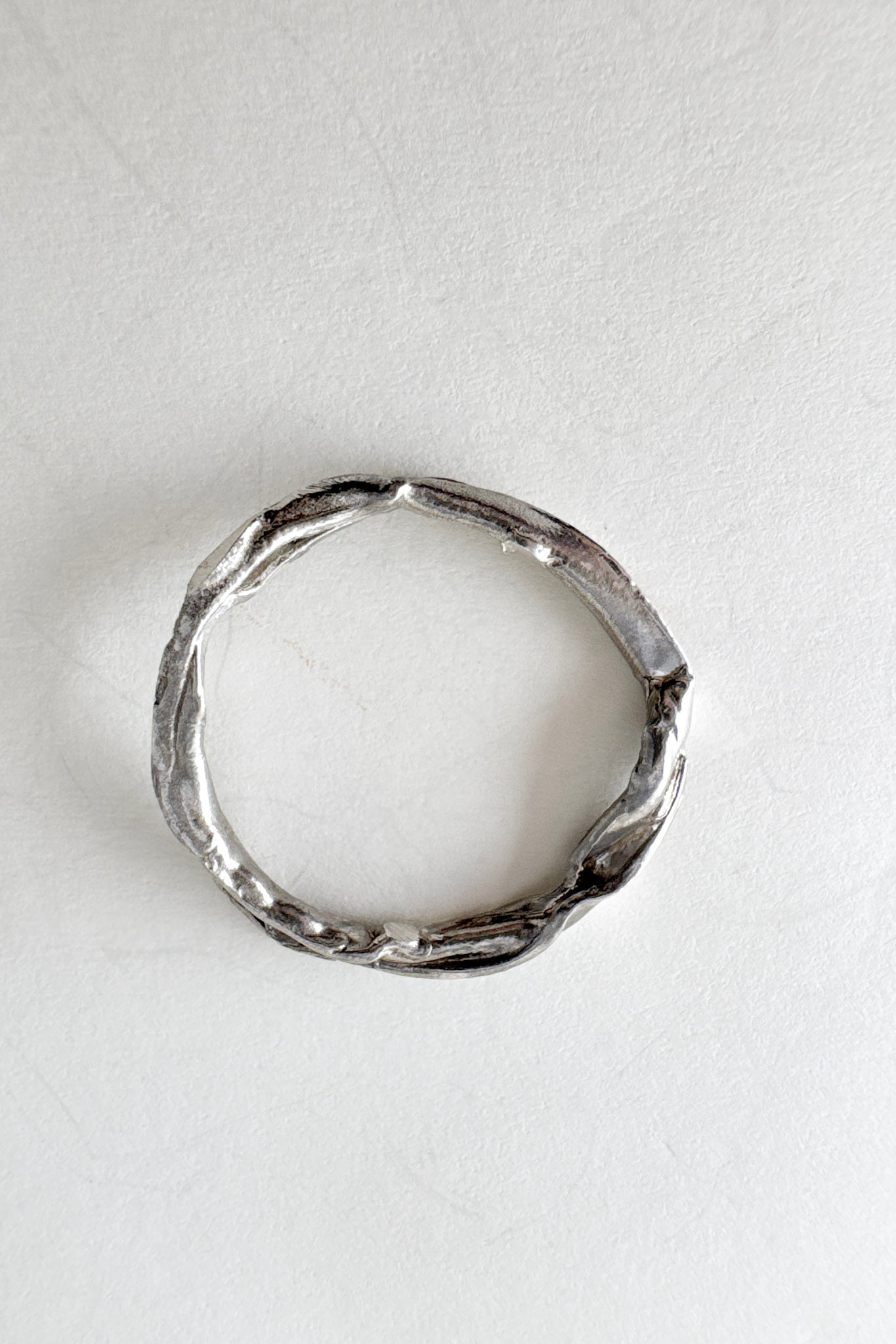 Silver ring viewed from above, showcasing its circular shape and organic texture with small lab-grown diamonds.