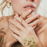 Primer plano de una modelo luciendo la Candonga Espiga, en un ambiente cálido con plantas secas y tonos naturales.