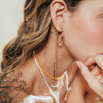 Close-up detail of the Espiga hoops worn by the model, highlighting the organic shape and artisanal character of the piece.