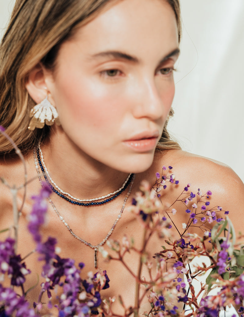 Model wearing the Flower Wing Earrings, handmade gold-plated jewelry with an organic texture.