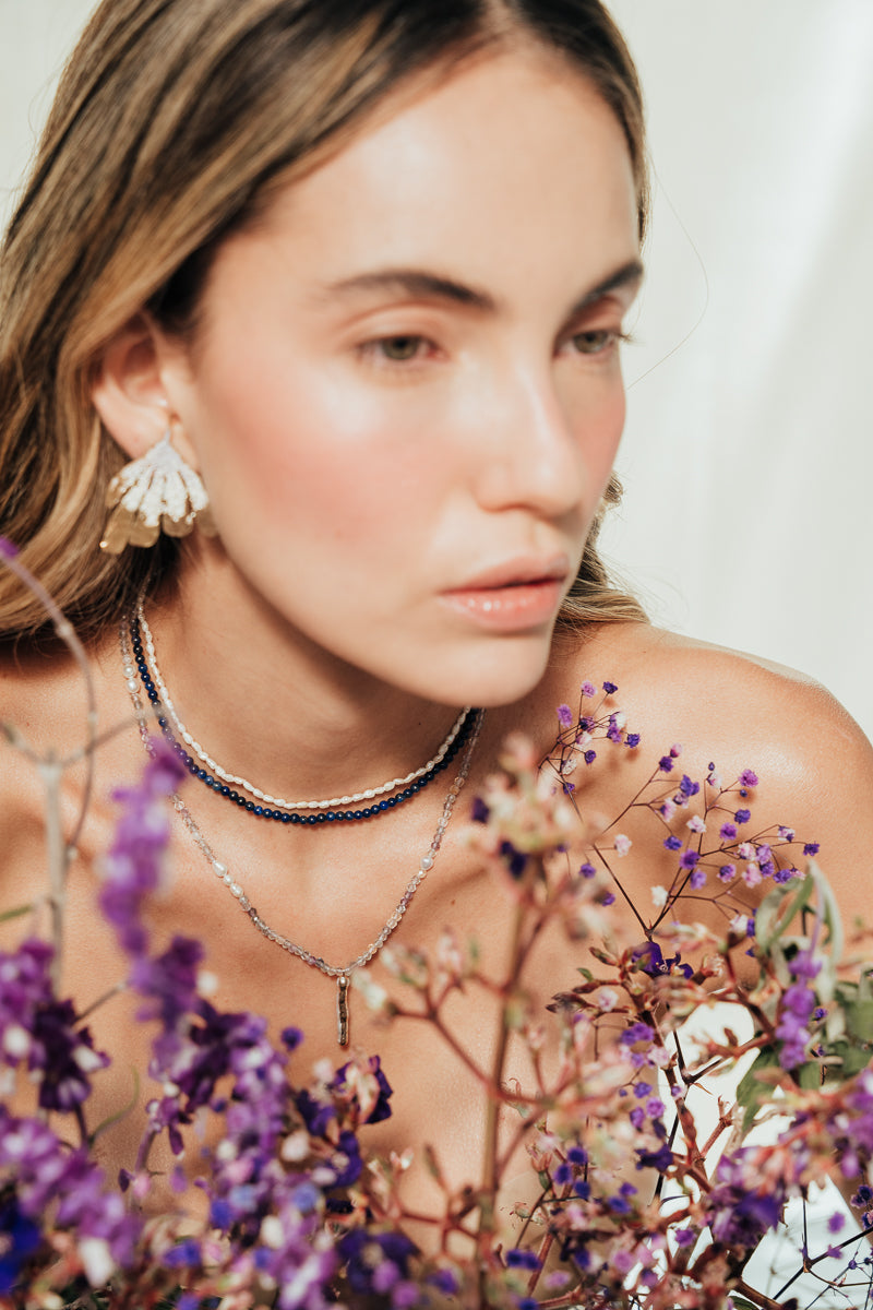 Model wearing the Flower Wing Earrings, handmade gold-plated jewelry with an organic texture.