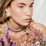 Model wearing the Flower Wing Earrings, handmade gold-plated jewelry with an organic texture.