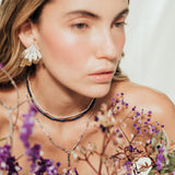 Model wearing the Flower Wing Earrings, handmade gold-plated jewelry with an organic texture.