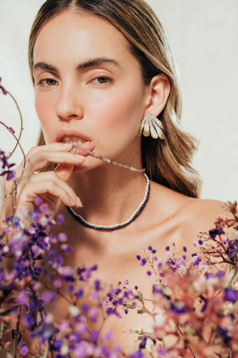Portrait of a model wearing Flower Wing Earrings, an artistic design inspired by petals