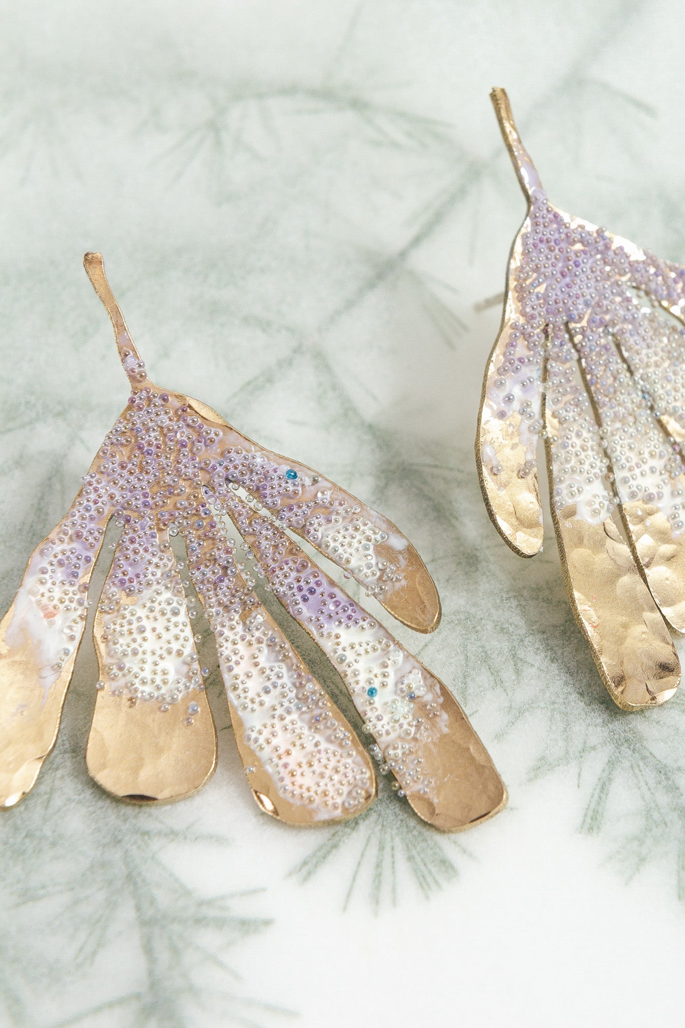 Lavender Flower Wing Earrings photographed close up, showing glass pearls and handcrafted finish.