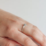 Hand wearing a handcrafted silver ring with a textured finish and an artisanal look.