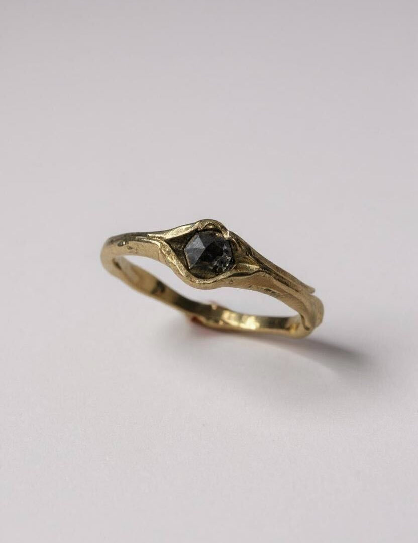 Side-angled view of the 10k yellow gold ring with a salt-and-pepper diamond, showing the organic sculpted band.