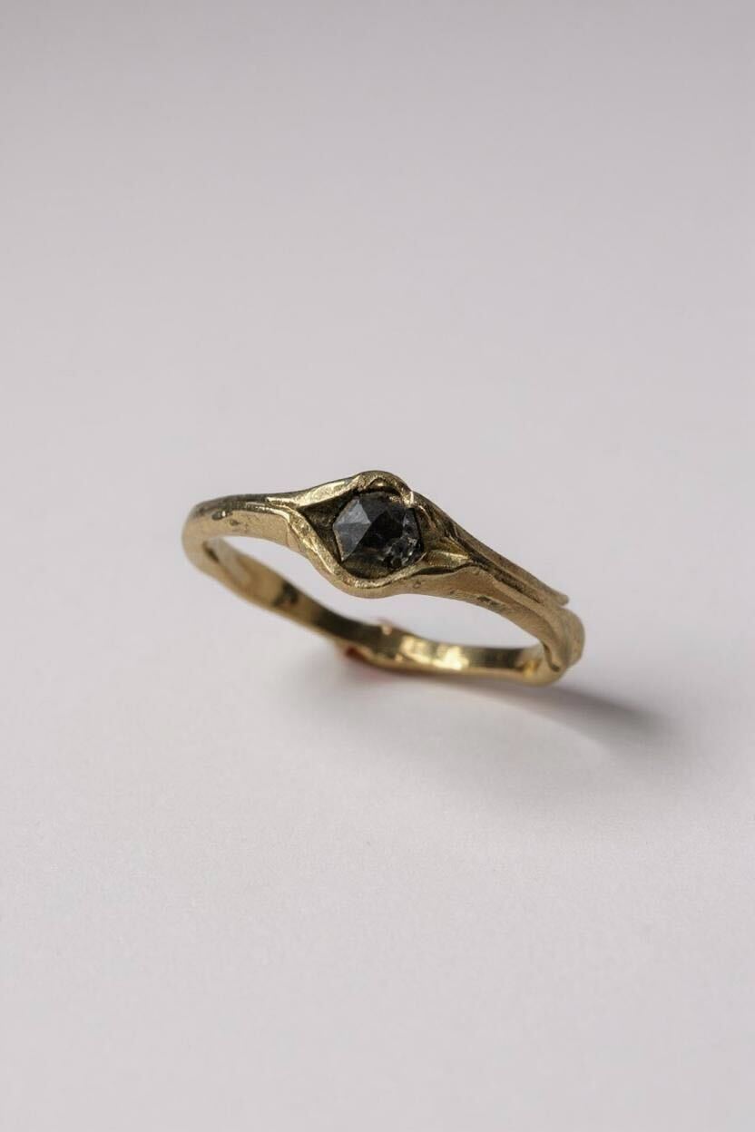 Side-angled view of the 10k yellow gold ring with a salt-and-pepper diamond, showing the organic sculpted band.