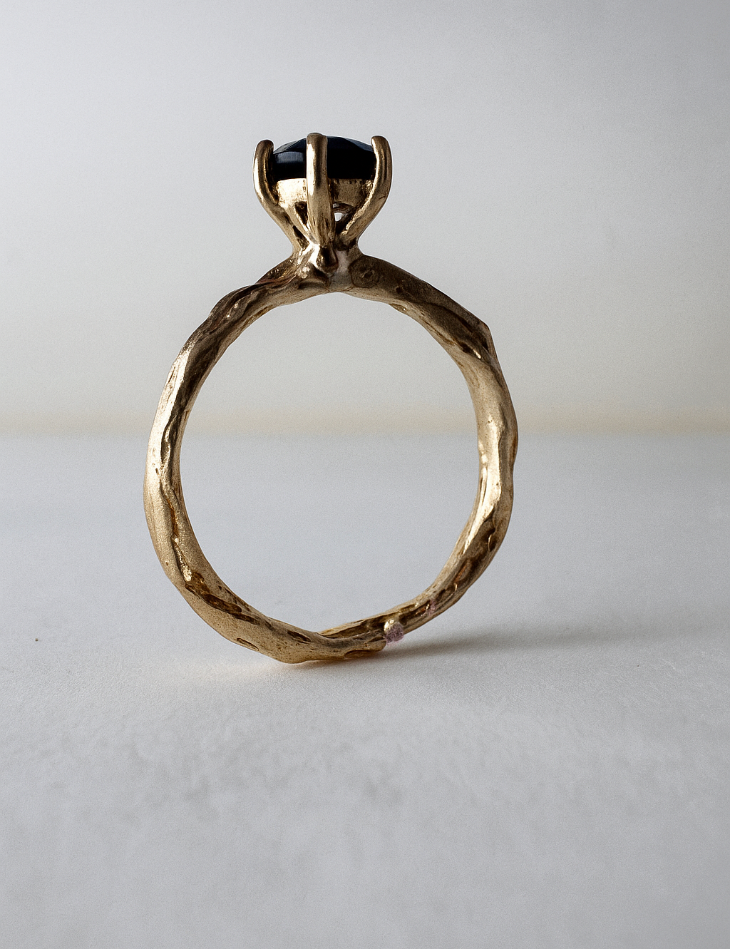 10k yellow gold ring with a London blue topaz set in a sculpted organic band, shown front-facing on a light background.