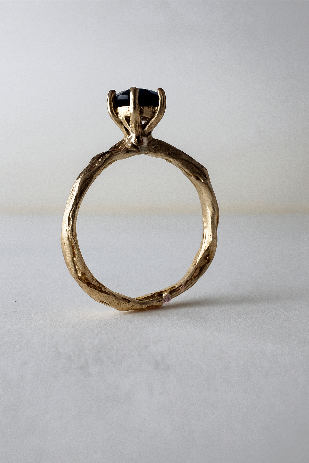 10k yellow gold ring with a London blue topaz set in a sculpted organic band, shown front-facing on a light background.