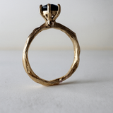 10k yellow gold ring with a London blue topaz set in a sculpted organic band, shown front-facing on a light background.
