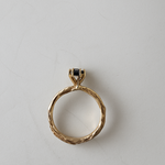ack view of the 10k yellow gold ring with London blue topaz showing the organic and sculpted band on a white background.