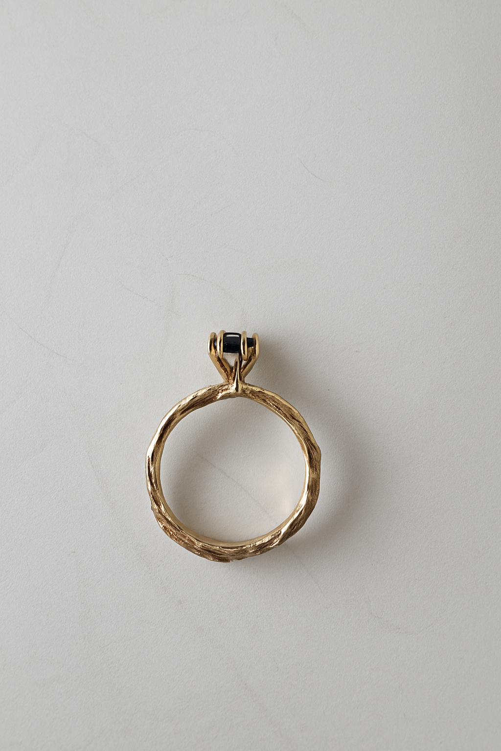 ack view of the 10k yellow gold ring with London blue topaz showing the organic and sculpted band on a white background.