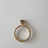 ack view of the 10k yellow gold ring with London blue topaz showing the organic and sculpted band on a white background.