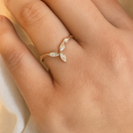 Rose gold Marqueza ring with zircons worn on a hand, photographed over soft fabric.