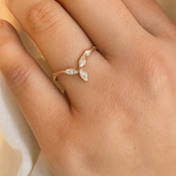 Rose gold Marqueza ring with zircons worn on a hand, photographed over soft fabric.