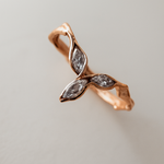 Angled side shot of the rose gold Marqueza ring, showing its delicate zircon stones and sculptural band.